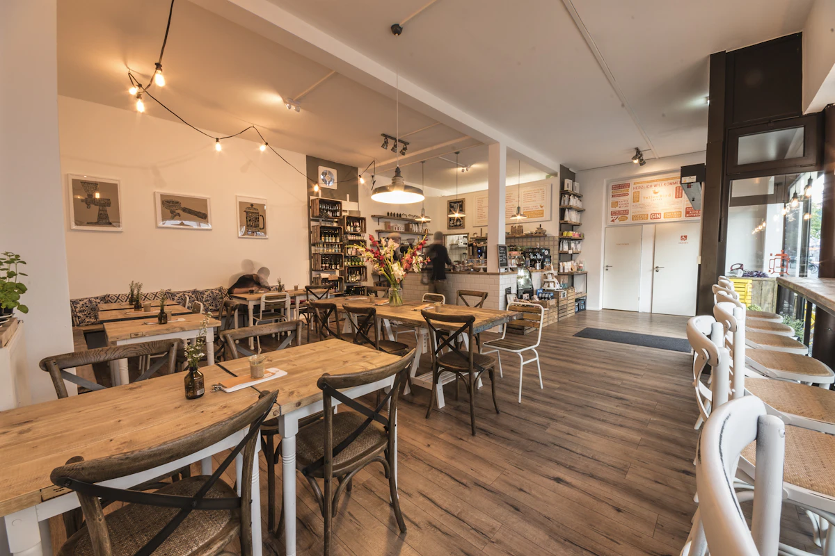 Comedor con mesas de madera y botellas en las estanterías
